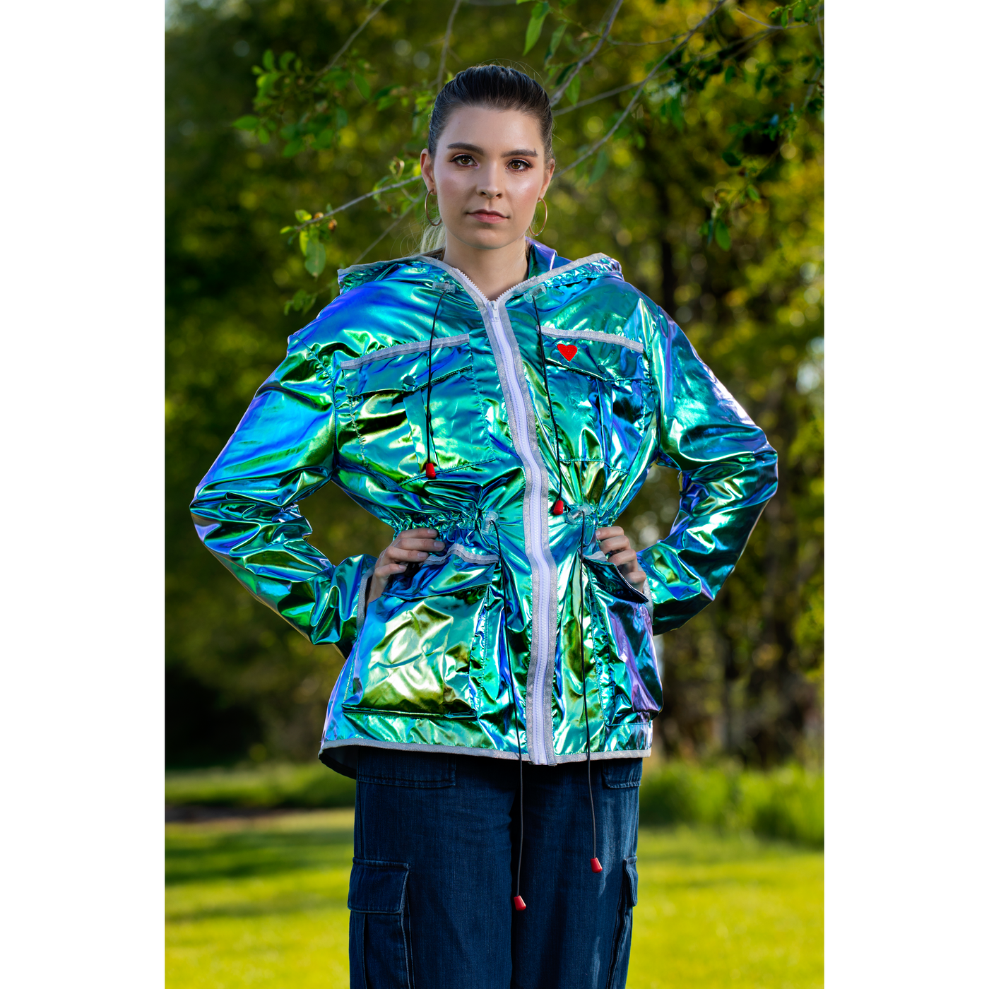 Image of a woman wearing a metallic green women’s mid-season jacket with the hood down.
